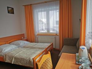 1 dormitorio con cama, mesa y ventana en Willa Hamernik AGROTURYSTYKA, en Tylicz