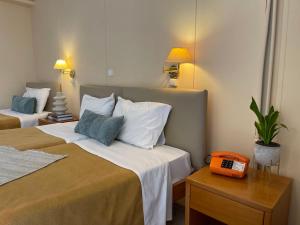 a hotel room with two beds and a phone on a table at El Greco Hotel in Heraklio Town