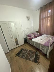 a bedroom with a bed and a mirror and a rug at Elle Guest House Sinaia in Sinaia