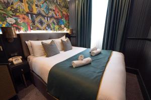 um quarto de hotel com uma cama com toalhas em Hyde Park Green em Londres