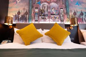 een slaapkamer met een bed met 2 gele kussens bij Hyde Park Green in Londen