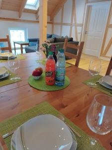 una mesa de madera con dos botellas y vasos. en Kleine Auszeit 1, en Forst