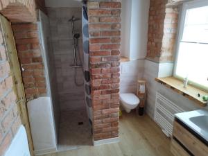 a bathroom with a brick wall and a shower at Kleine Auszeit 2 in Forst