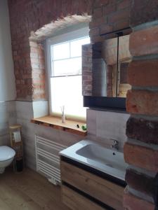 a bathroom with a sink and a brick wall at Kleine Auszeit 2 in Forst