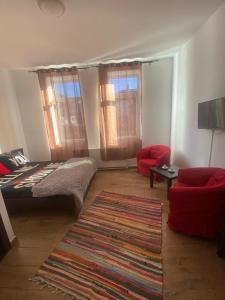 a living room with a bed and a red couch at Elle Guest House Sinaia in Sinaia