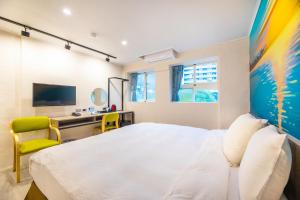 1 dormitorio con 1 cama blanca grande y escritorio en King Hot Spring Hotel, en Jiaoxi