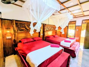 two beds in a room with wooden walls at Maika safari lodge in Udawalawe +99 photos