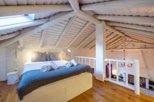 1 dormitorio con 1 cama grande en el ático en Casa dos Cantoneiros, en Aljezur