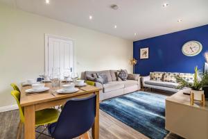 uma sala de estar com uma mesa e um sofá em 4 Bed Terraced House in Beeston with Convenient City Centre Access em Nottingham