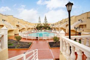 uitzicht op het zwembad vanaf het balkon van een hotel bij Liomor Luxury in Caleta De Fuste