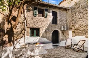 a stone house with a patio with a table and chairs at Ellen traditional House in Alexandros