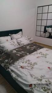 a bed with a blanket with flowers on it at CozyApartment14 in Roşu