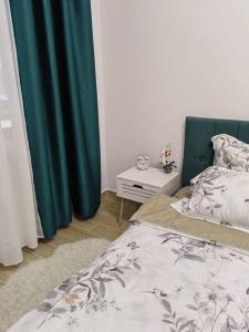 a bedroom with a bed and a night stand next to a table at CozyApartment14 in Roşu