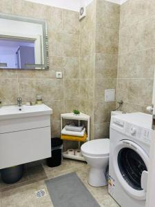 a bathroom with a washing machine and a toilet at CozyApartment14 in Roşu