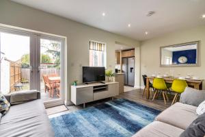 uma sala de estar com um sofá e uma televisão em 4 Bed Terraced House in Beeston with Convenient City Centre Access em Nottingham