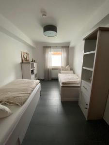 1 dormitorio con 2 camas y ventana en Ferienwohnung Flussufer No.12, en Schweich