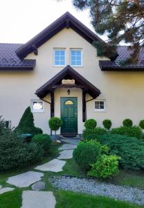 a house with a green door and a walkway at Molonówka Guest House in Szczyrk