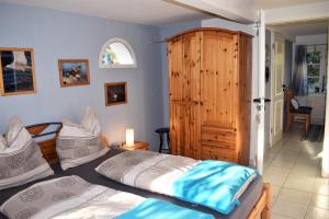1 dormitorio con 2 camas y armario de madera en Auszeit unter Reet, en Bordelum