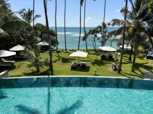 a swimming pool with a view of the ocean at Eraeliya Villas & Gardens in Weligama