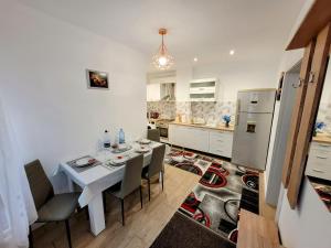 a kitchen with a table and chairs and a refrigerator at Casa Feli in Braşov