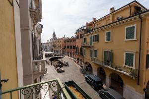 einen Balkon mit Blick auf eine Straße mit Gebäuden in der Unterkunft Domus Verona - Centralissima e antica Residenza Cappello in Verona