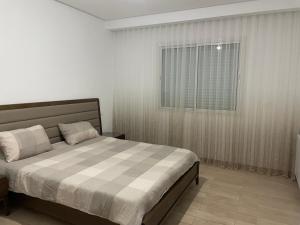 a bedroom with a bed and a window at Appartement Les Pergolas in Ariana