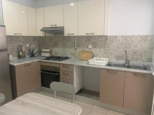a kitchen with white cabinets and a sink at Appartement Les Pergolas in Ariana