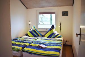 una camera da letto con un letto con lenzuola a righe e una finestra di Villa Lullyhill a Bargum