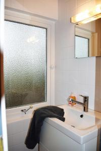 baño blanco con lavabo y ventana en Villa Lullyhill, en Bargum