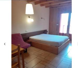 a bedroom with a bed and a chair and a table at Hotel restaurant la terrasse du mont bar hotel leydier in Allègre