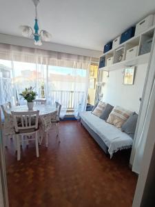 ein Wohnzimmer mit einem Sofa und einem Tisch in der Unterkunft Fleur Australe in Gruissan