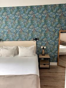 サン・ジャン・ド・リュズにあるMosaikhotelの花柄の壁紙を用いたベッドルーム1室