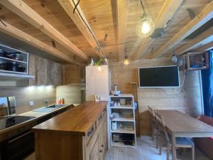 Il comprend une cuisine avec une table et une télévision murale. dans l'établissement Appartement 290 Moulin B - 1200 Châtel - Linga, à Châtel