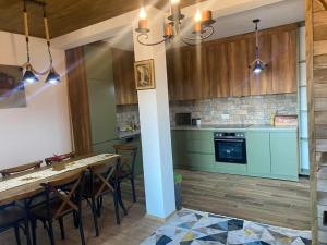 una cocina con mesa y algunas sillas. en Villa Gjelbër en Prizren