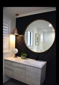 a bathroom with a sink and a mirror at Inspire Boutique Apartments in Devonport
