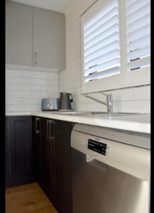 uma cozinha com um lavatório e uma bancada em Inspire Boutique Apartments em Devonport