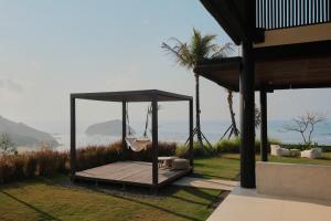 a porch with a hammock and a view of the ocean at Somewhere Lombok in Kuta Lombok