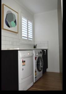 a washing machine in a kitchen with a window at Inspire Boutique Apartments in Devonport