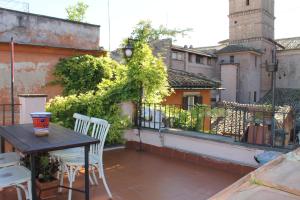un balcon avec une table et des chaises sur un immeuble dans l'établissement Casa Greco - Attico con terrazza, Trastevere, à Rome