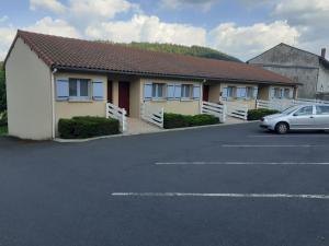 une voiture garée dans un parking à côté d'un bâtiment dans l'établissement Hotel restaurant la terrasse du mont bar hotel leydier, à Allègre