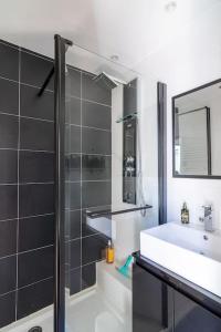 La salle de bains est pourvue d'un lavabo, d'un miroir et d'une douche. dans l'établissement Bel Appartement hyper centre, 2 chambres avec SDB, à Saumur