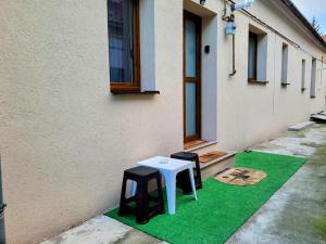 a pair of stools sitting on a green floor next to a building at Casa Feli in Braşov