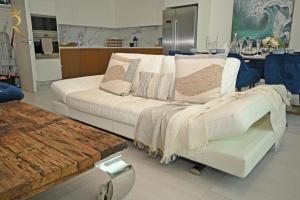 a living room with a white couch with pillows at 1BR Loft Soul Beach Escape - Mamsha Al Saadiyat in Abu Dhabi