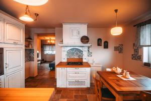 a kitchen with white cabinets and a wooden table at Posest Kunigunda in Šmartno v Rožni Dolini