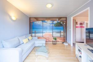 Una sala de estar con un sofá y vista al mar. en La Maresquerie, en Grandcamp-Maisy