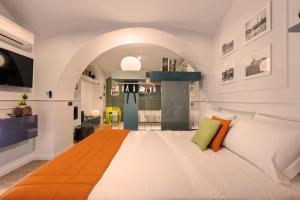 sypialnia z dużym białym łóżkiem z kolorowymi poduszkami w obiekcie Lata Rana Colosseum Luxury Loft w Rzymie