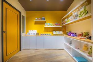 a childs play room with yellow walls and white shelves at King Hot Spring Hotel in Jiaoxi