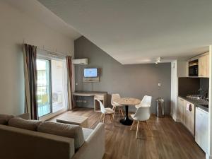 a living room with a couch and a table at Les appartements du Clos de la Chartreuse By Ateya in Aix-en-Provence