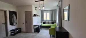 ein Wohnzimmer mit einem grünen Stuhl und einem Tisch in der Unterkunft LOFT HOUSE in Schidnyzja