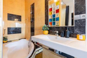 a bathroom with a white sink and a mirror at BNB Slovakia Royal City Vista Apartment in Bratislava